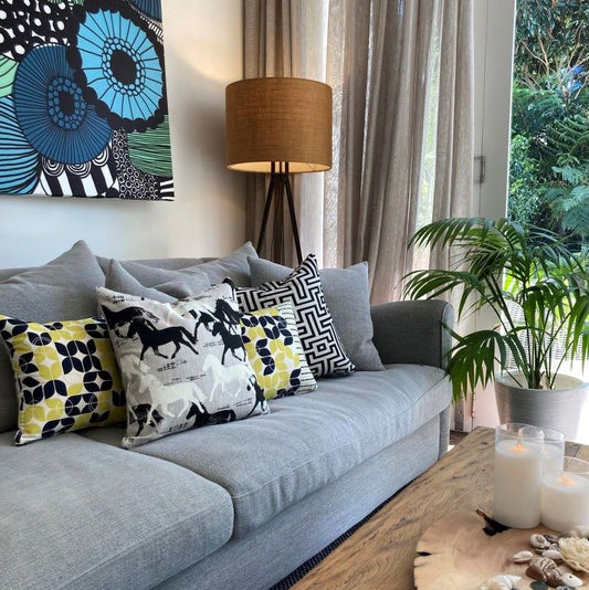 beautiful couch with eco interiors cushions and marimekko print on the wall