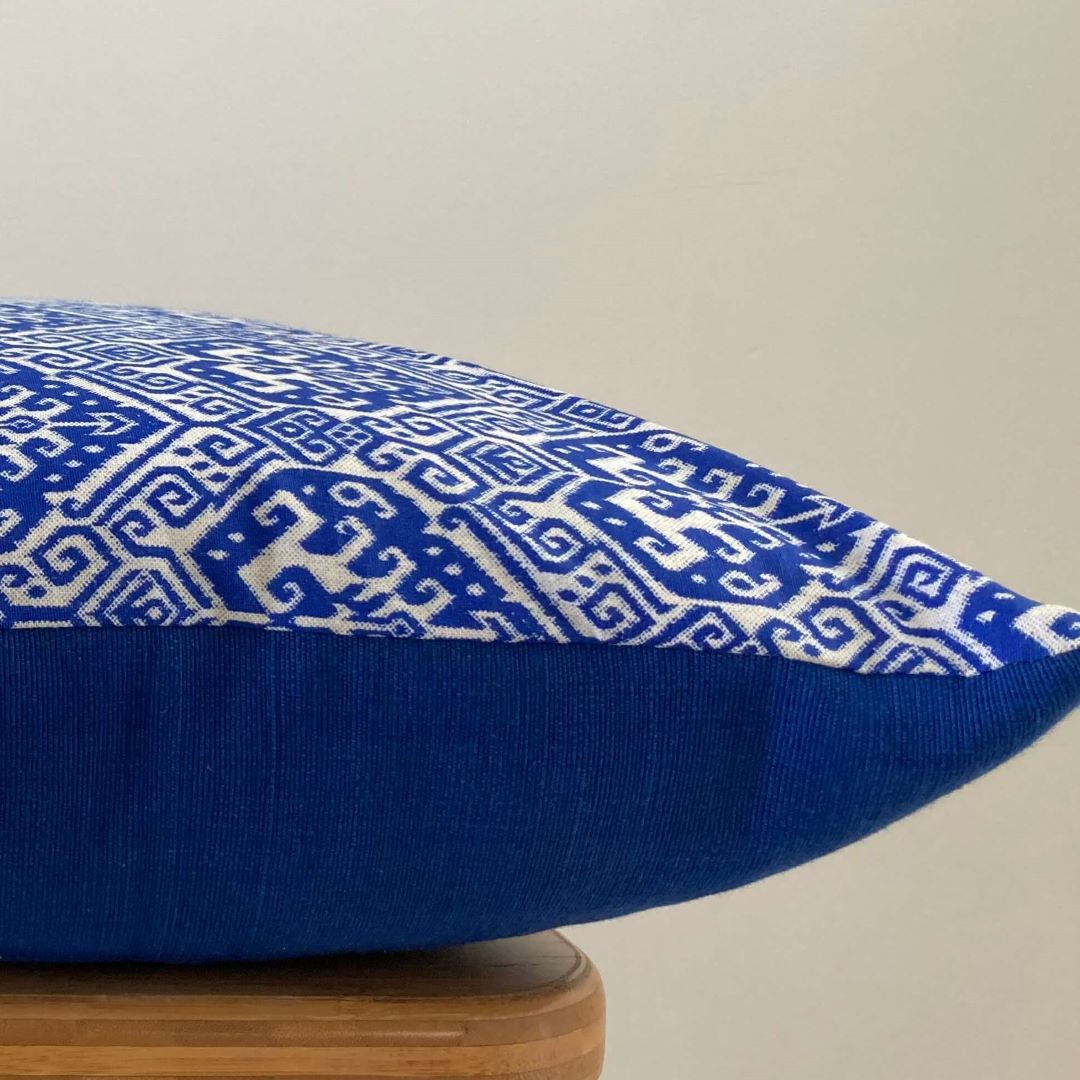 Side view of blue block print cushion cover showing front and back