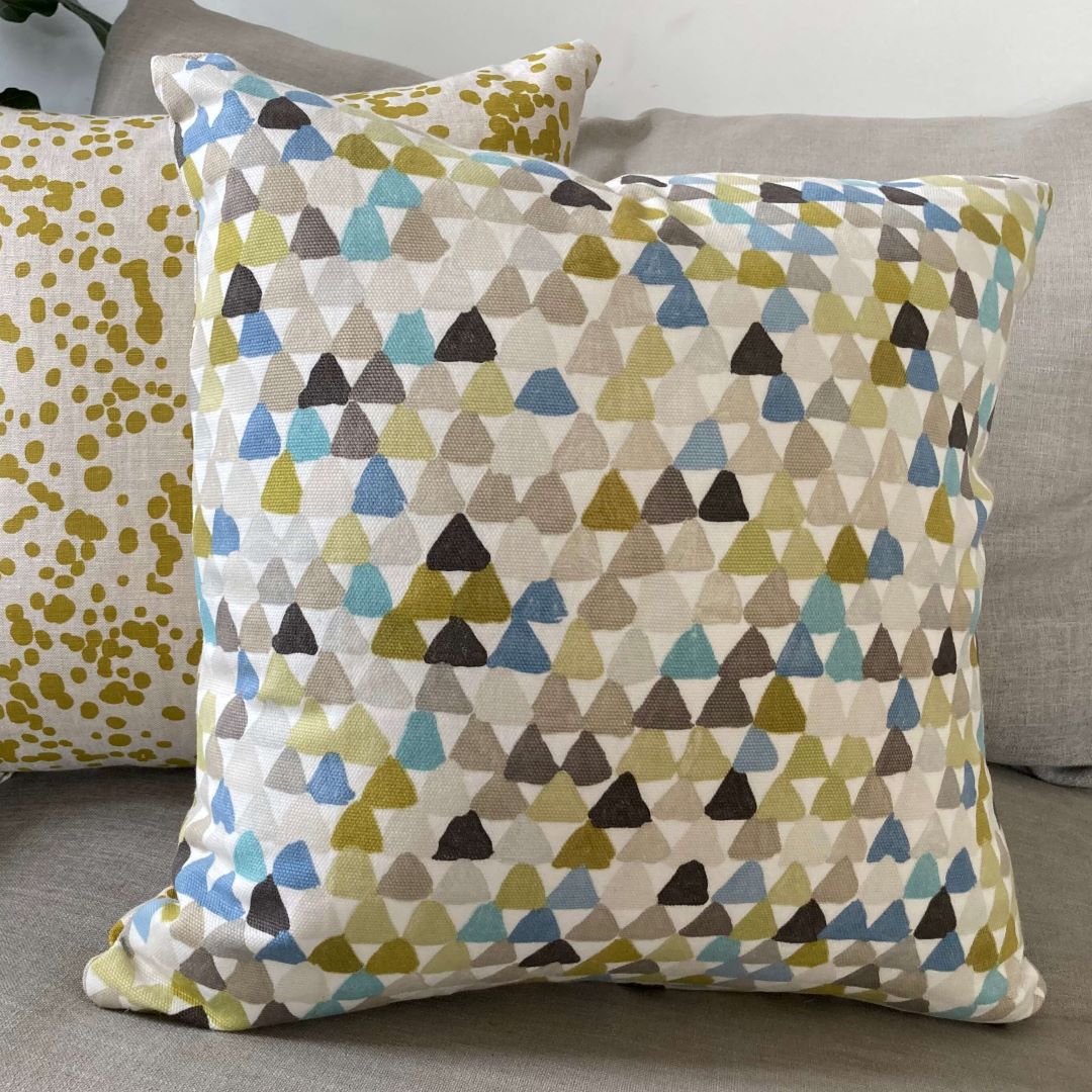 Spots and triangles cushion cover on a couch
