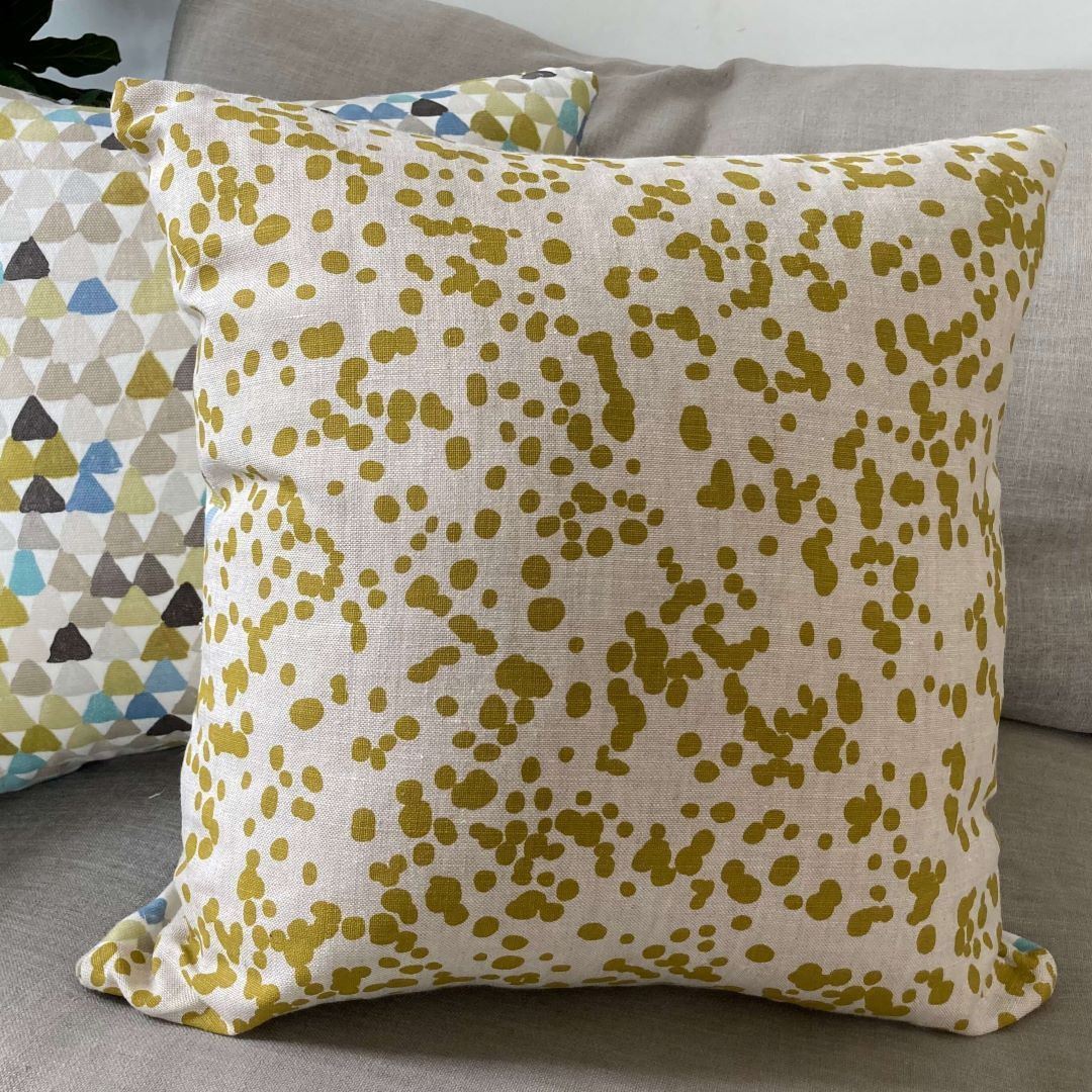 Spots and triangles cushion cover on a couch