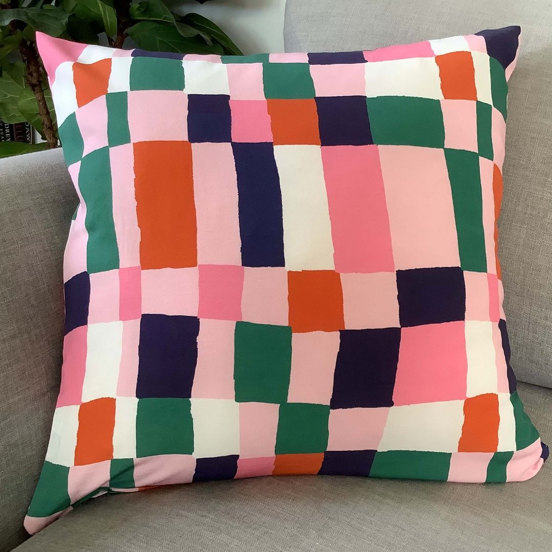 Navy and pink cushion cover on a couch