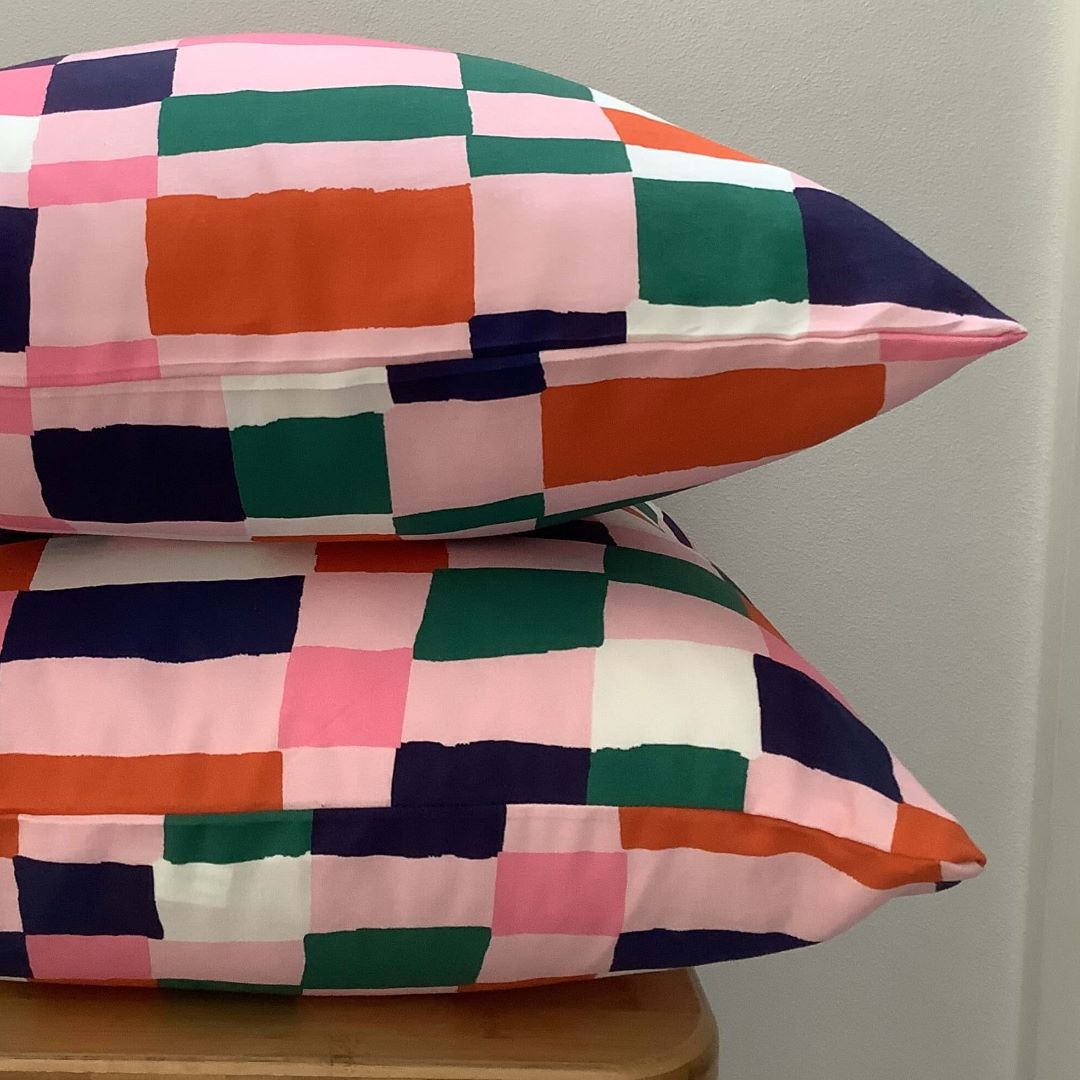 Side view of navy and pink cushion cover showing front and back in same fabric