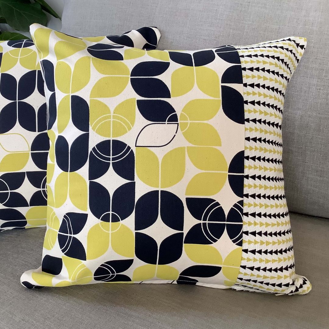 large and small geometrics cushion cover on a couch with arches and triangles cushion cover behind